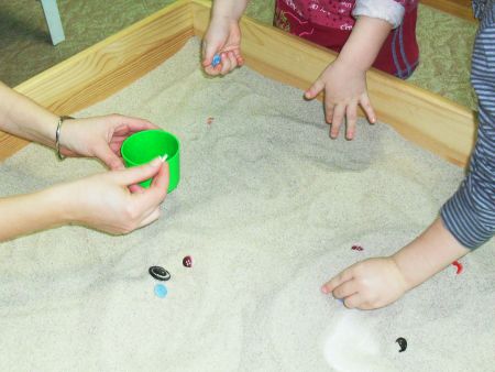 Поиск «потерянных» парных пуговиц в песочнице.